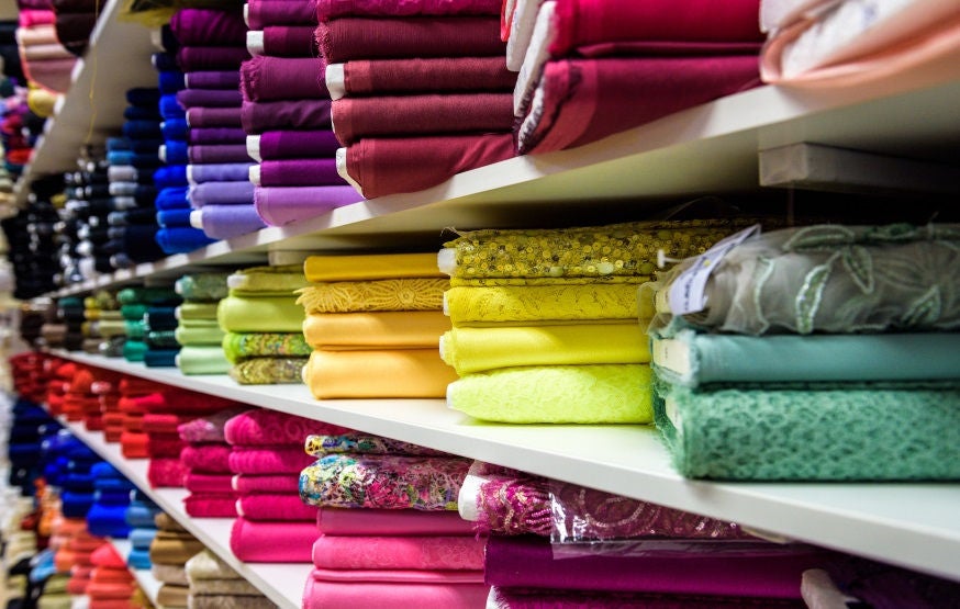 Rolls of fabric and textiles in a factory shop or  store or bazar. Multi different colors and patterns on the market. Industrial fabrics.